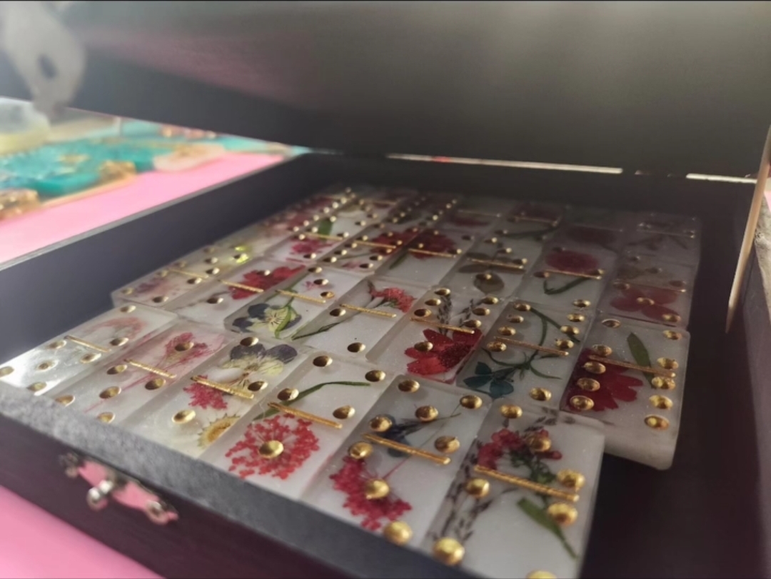 Teal and gold resin dominoes being crafted